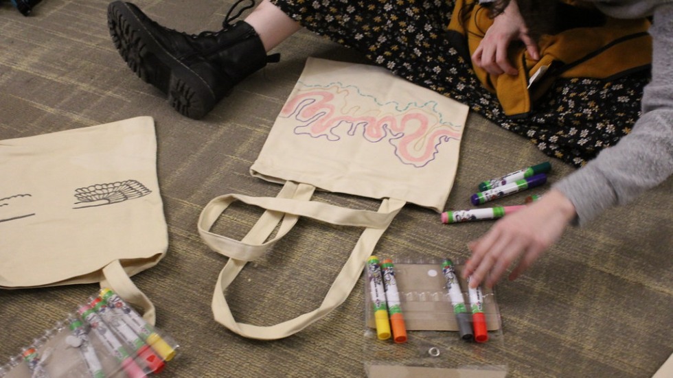 Student drawing on a canvas bag